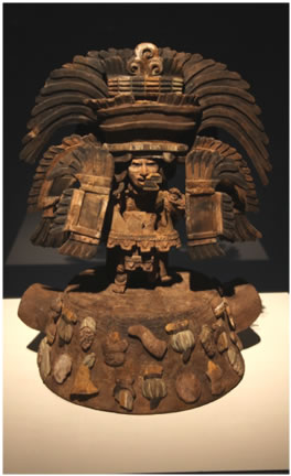 Censer with an standing figurine with and extraordinary headdress, holding two plates one on each hand, representing the Butterfly god. 
